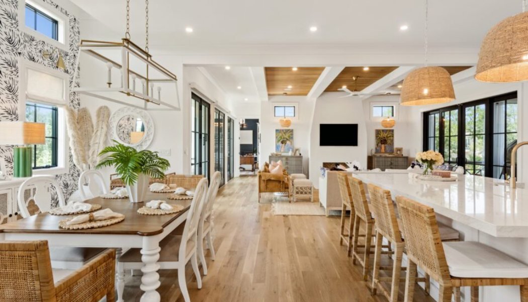 Open coastal kitchen and dining room with woven pendants and rattan chairs