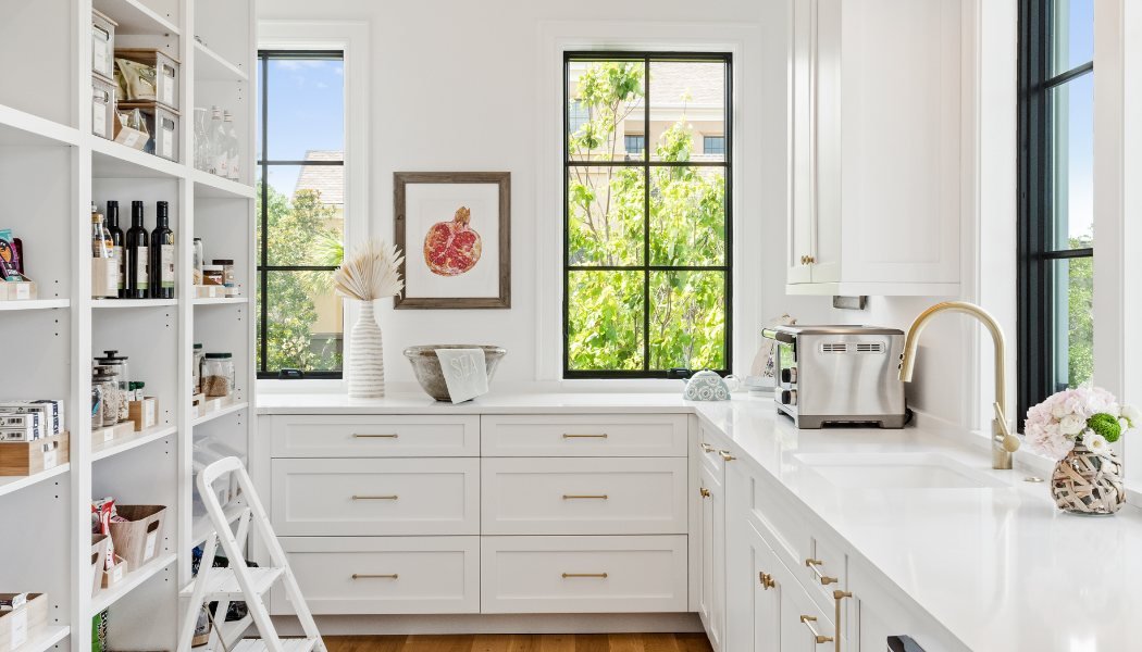 White butler’s pantry with open shelving, brass hardware and black steel windows
