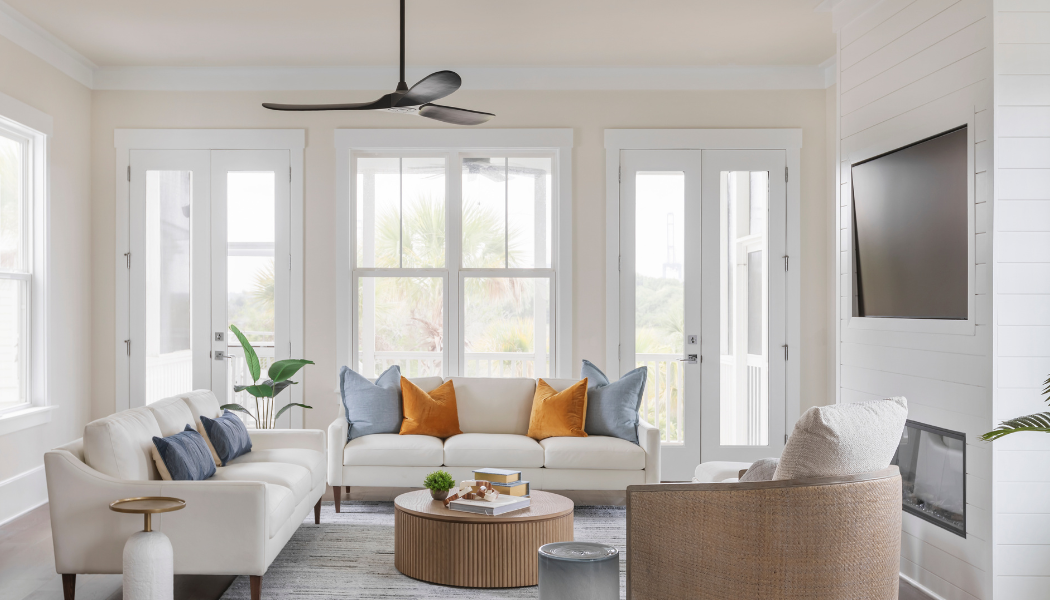 Coastal living room with cream sofas, blue and amber pillows and a fluted coffee table