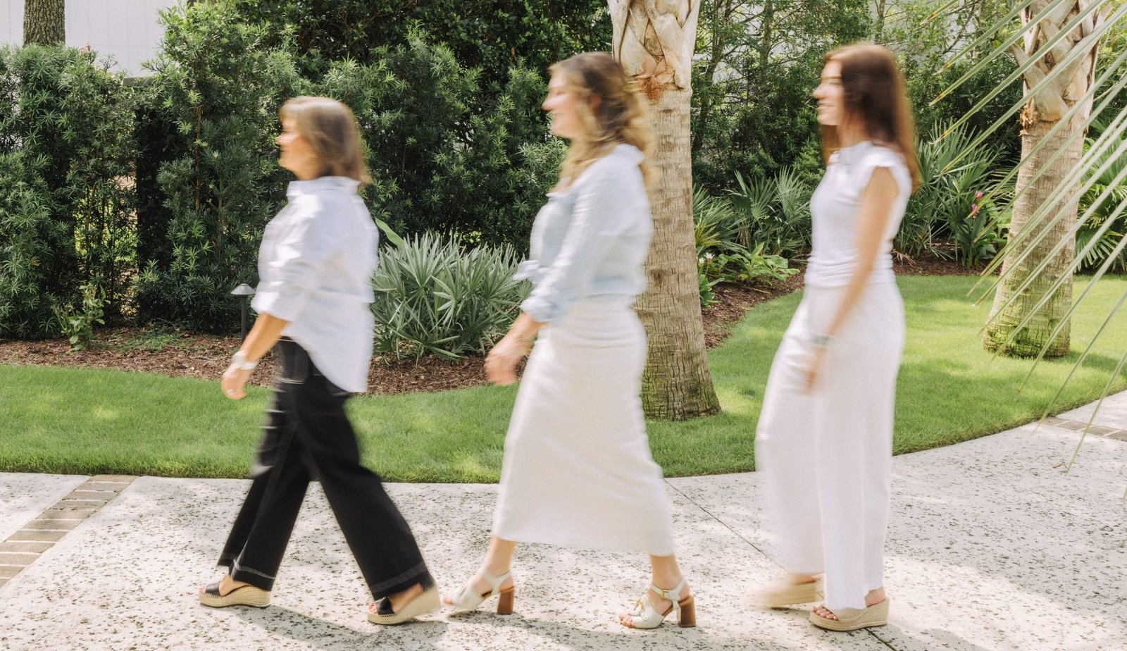 The Andrea Dussault Design team walking together along a garden path, captured in motion