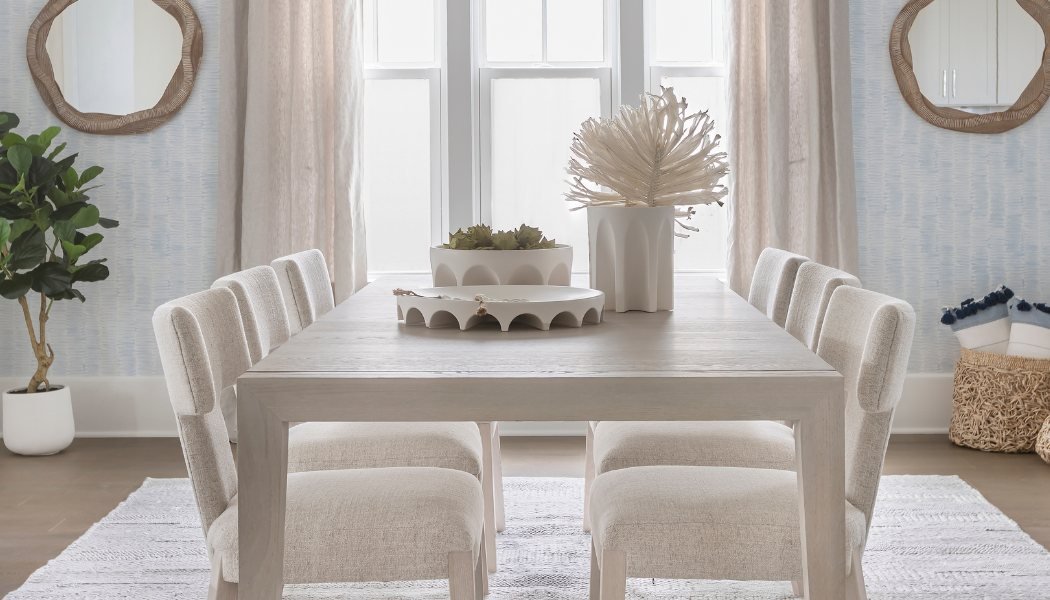 Pale oak dining table with bouclé chairs, scalloped ceramics and organic wood mirrors