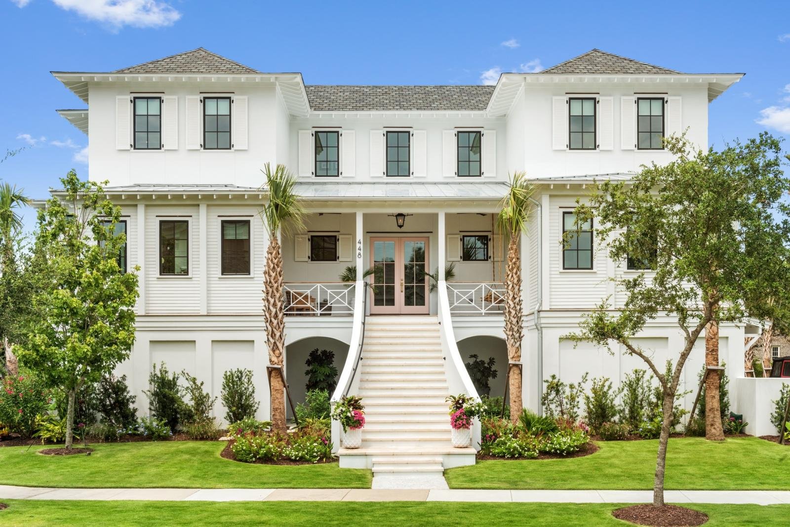White Sullivan's Island house with double stair, palms, and pink front doors