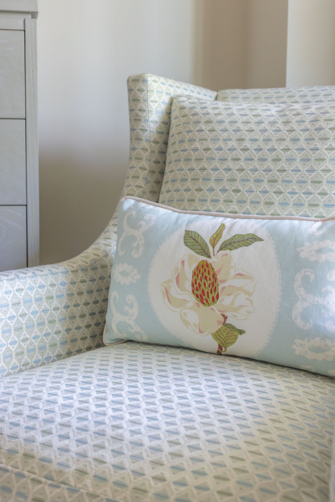 Magnolia lumbar pillow on a diamond-woven bedroom chair