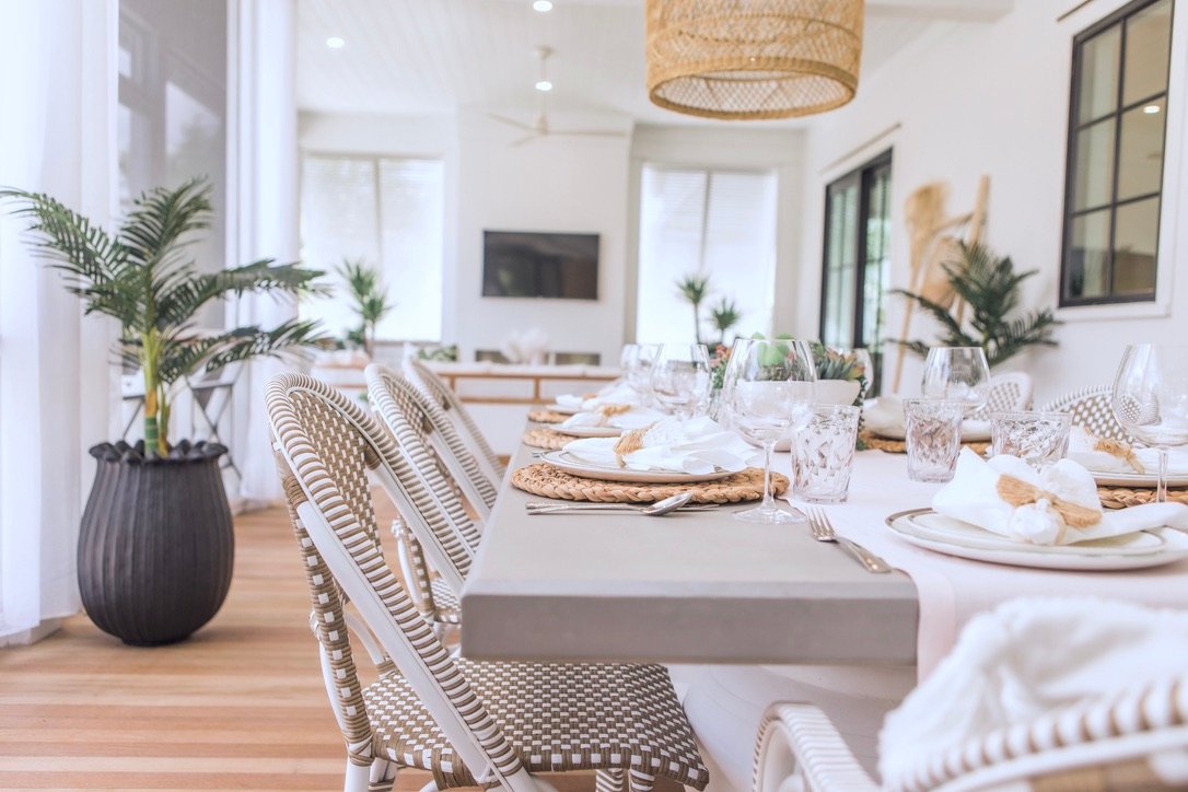 Long concrete table set for a crowd under a woven drum pendant