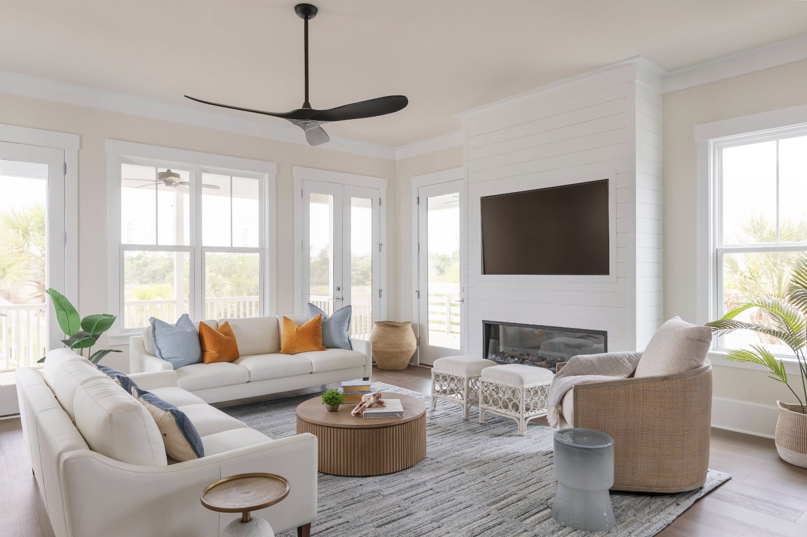 Living room with shiplap fireplace, ivory sofas, and marsh views