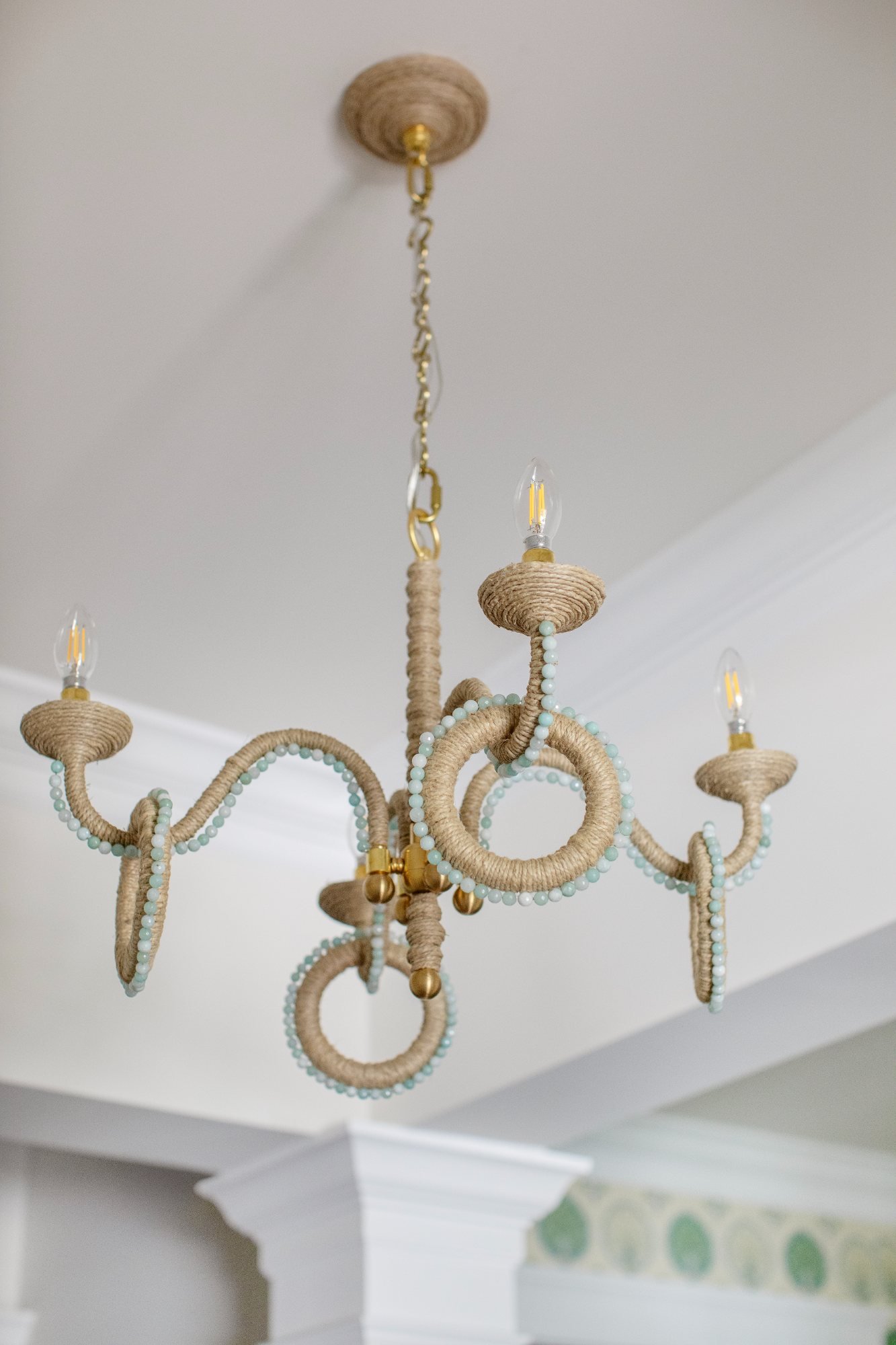 Jute-wrapped chandelier with pale green beading over the stair hall