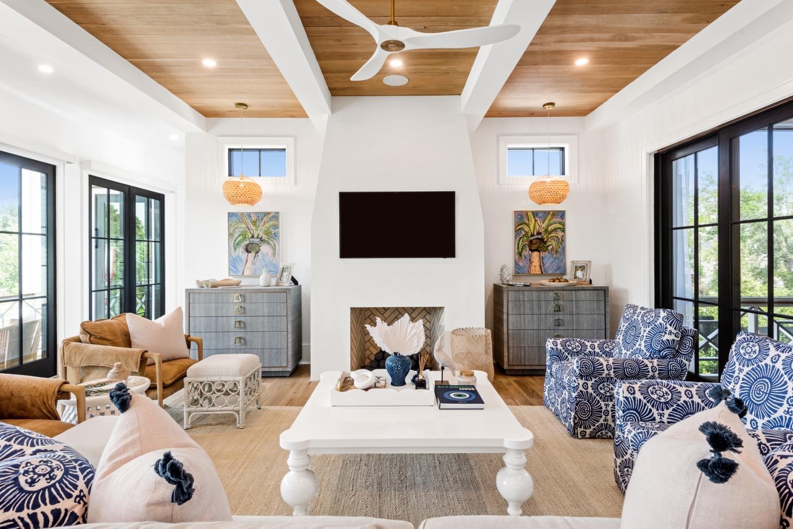 Living room with wood-plank ceiling, white fireplace, and blue block-print swivel chairs