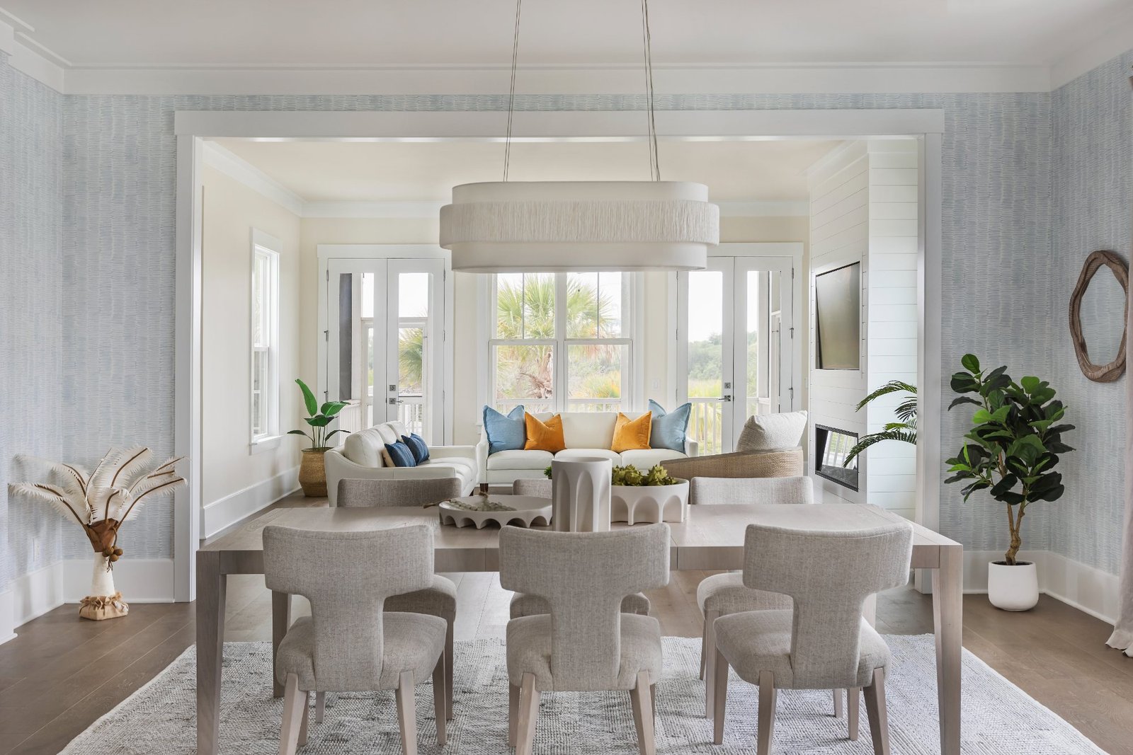 View across the dining table into the living room and palms beyond