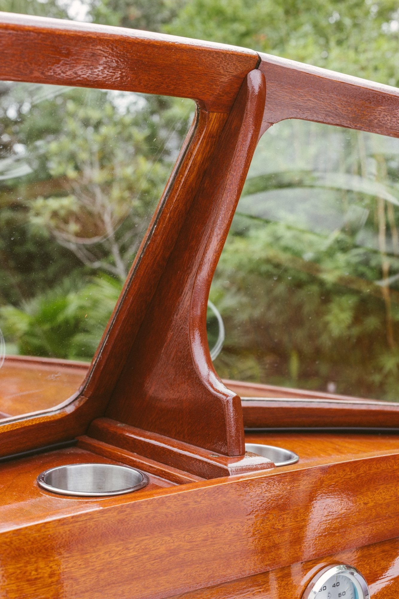 Windshield joinery and inset cupholders in varnished mahogany