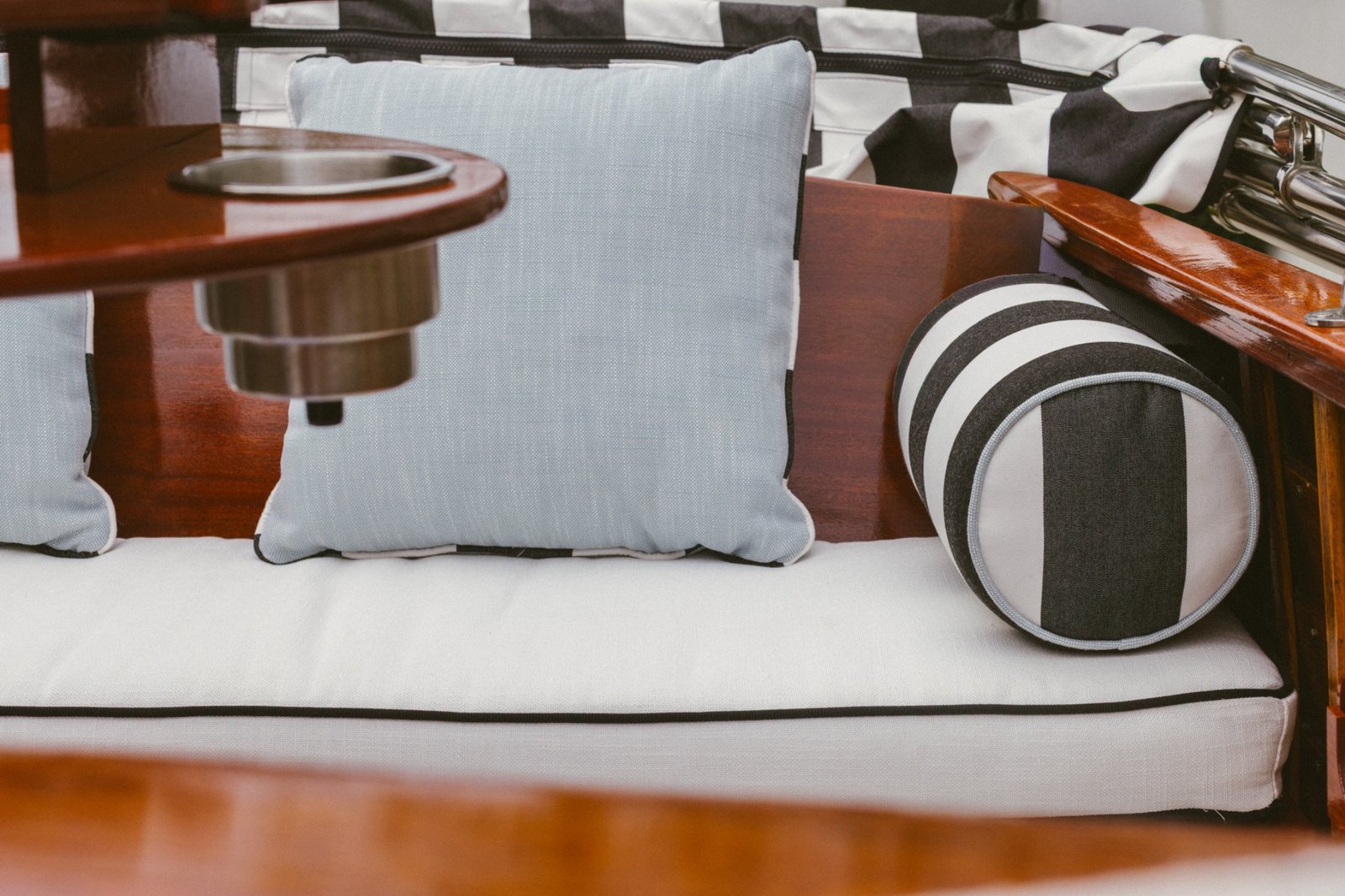 Custom bench cushion with a soft blue pillow and black-and-white striped bolster