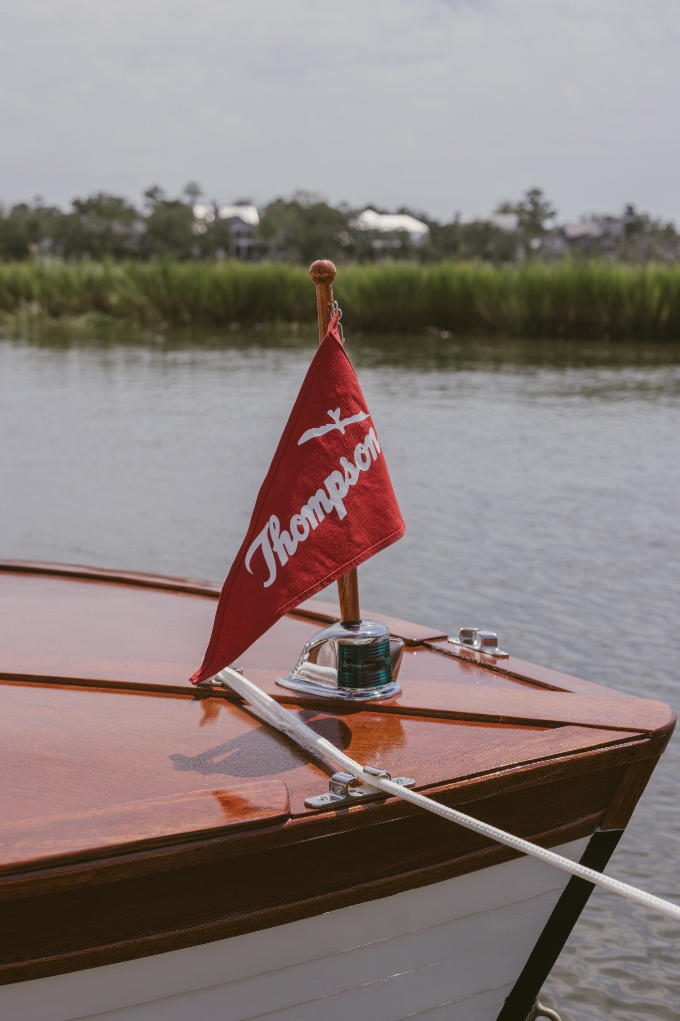 Red Thompson pennant flying from the bow staff over the marsh