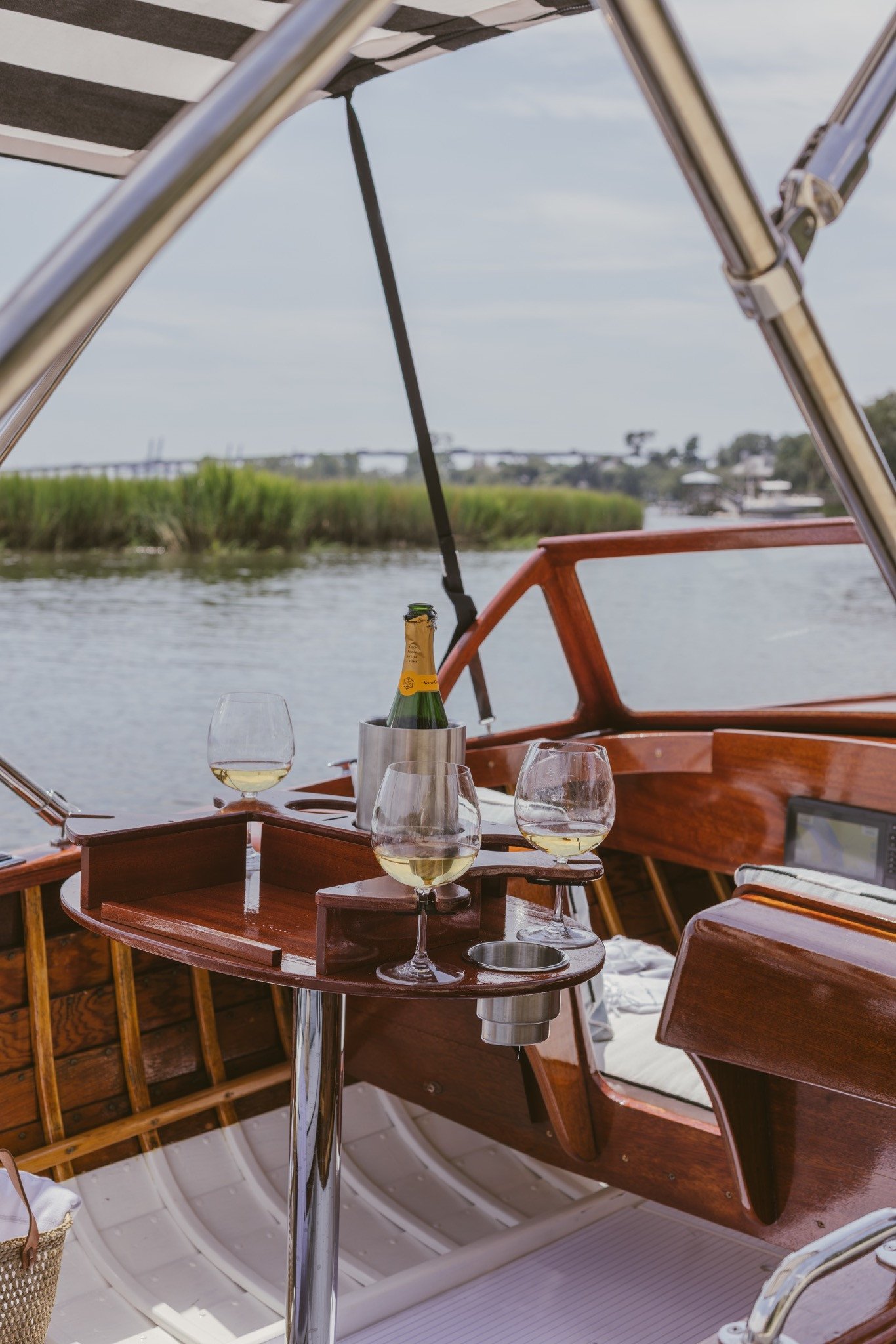 Champagne and glasses on the custom table under the striped bimini