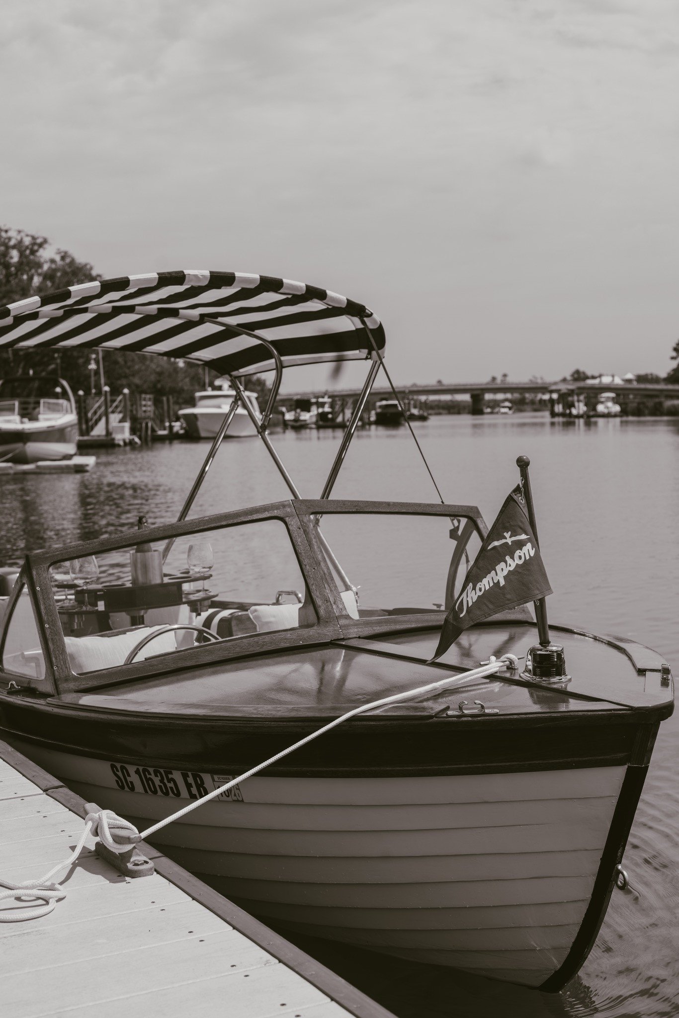 Old Saulty tied at the dock, bow and striped bimini in black and white