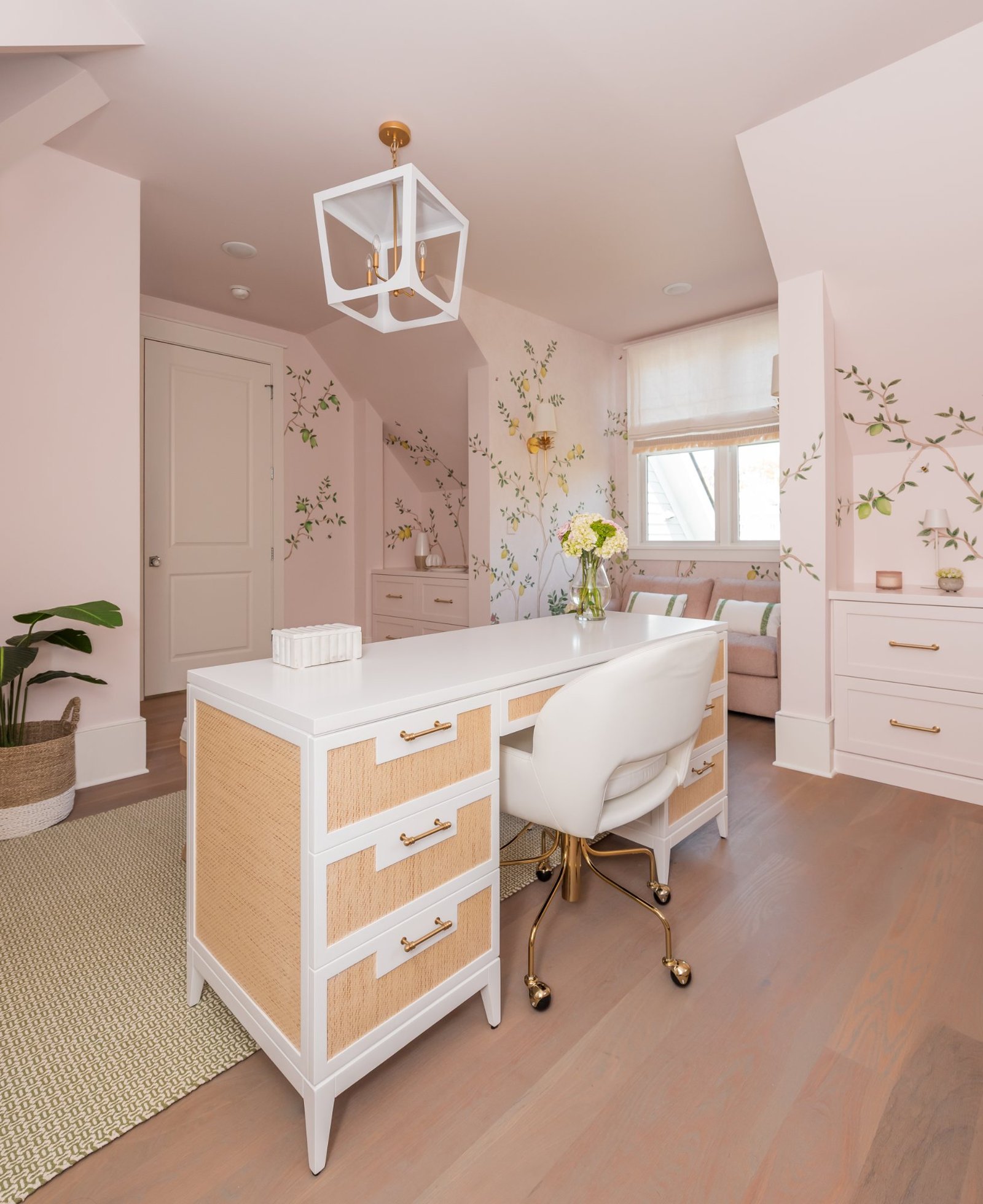Desk and rattan credenza beneath the mural, gold-framed mirror above