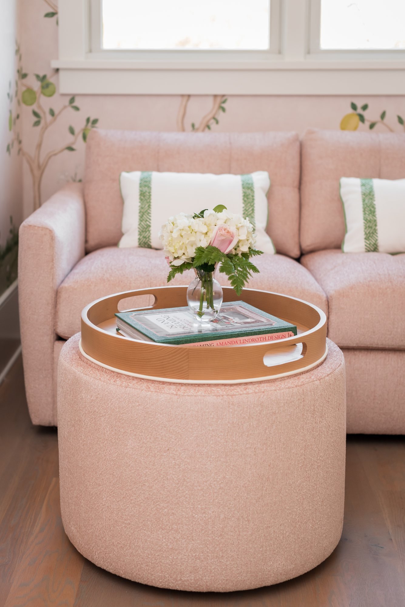 Bouclé ottoman with wood tray, books, and hydrangeas