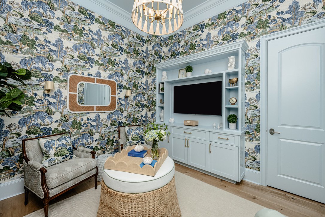 Media room with sky blue lacquered built-ins, beaded chandelier, and woven ottoman